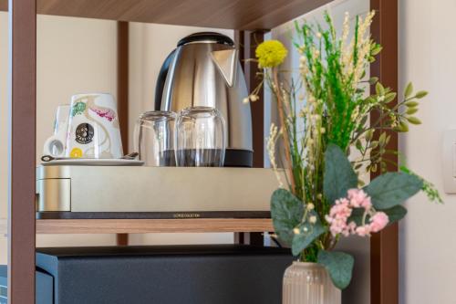 a shelf with vases of flowers in a kitchen at Illumi's Hotel in Villasimius