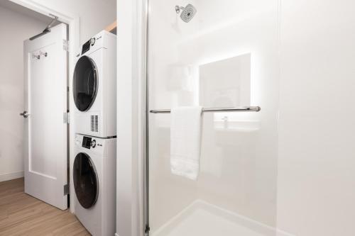 a bathroom with a washer and dryer next to a shower at YourSpace Hotels Chesapeake in Chesapeake