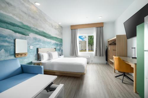 a hotel room with a bed and a desk at YourSpace Hotels Chesapeake in Chesapeake
