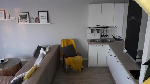 a living room with a couch and a kitchen at Widokówka in Tarnobrzeg