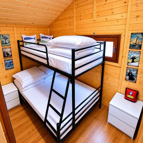 two bunk beds in a room with wooden walls at Domek na Orlej in Giewartów