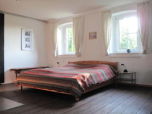 a bedroom with a bed and two windows at Forsthaus Castell in Castell