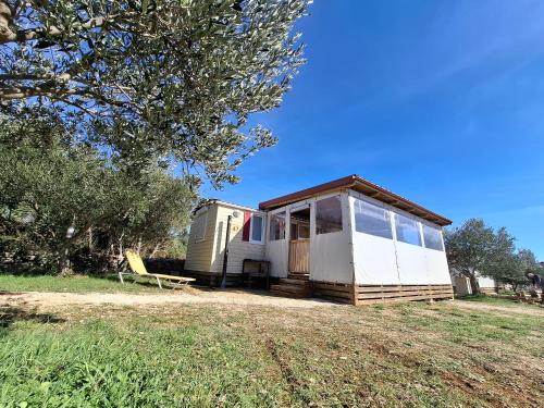 a tiny house sitting on top of a field at Mobile Home MEDITERRA in Pirovac