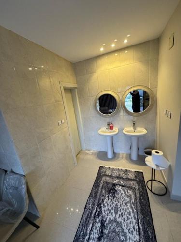 a bathroom with two sinks and two mirrors at شاليه إطلالة in Buraydah