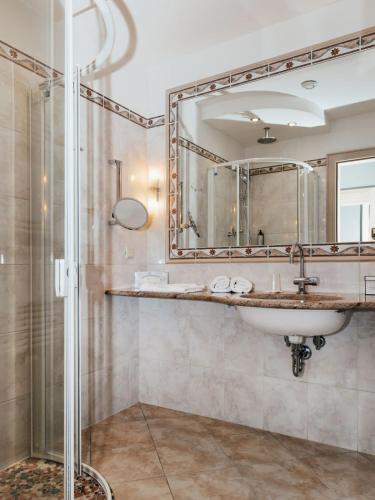 a bathroom with a sink and a mirror at Hotel Villa Rainer in Pörtschach am Wörthersee