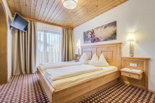 a bedroom with a large bed in a room at Gästehaus Restaurant Wiesenheim in Uderns