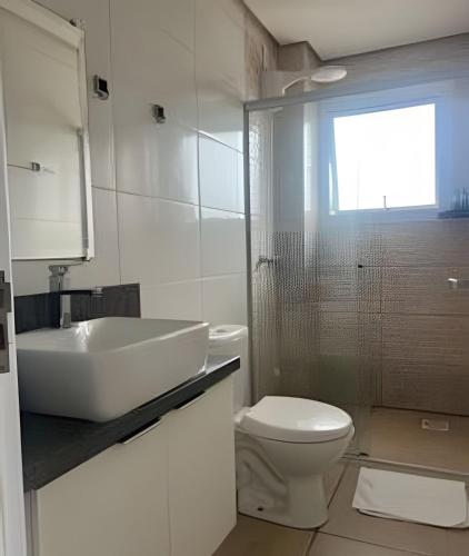 a white bathroom with a sink and a toilet at Apartamento - 2 Quartos * Completo * Central in Bento Gonçalves