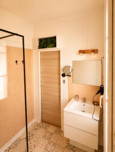 a bathroom with a sink and a shower at La Cour Du Puits, Chambre Darjeeling in Cormeilles
