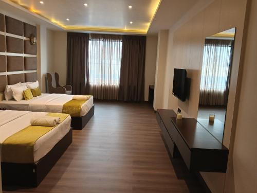 a hotel room with two beds and a flat screen tv at Borbon Hotel & Restaurant in Jowai