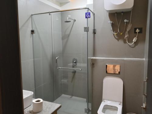 a bathroom with a glass shower with a toilet at Borbon Hotel & Restaurant in Jowai