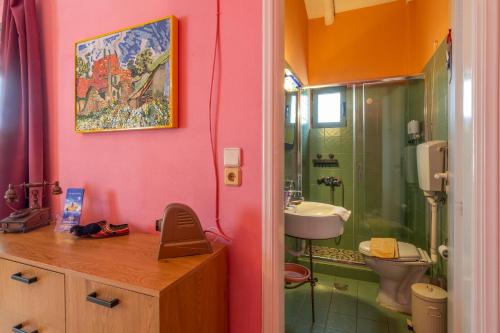 a pink bathroom with a sink and a toilet at Villa Kirki Apartments in Agia Effimia