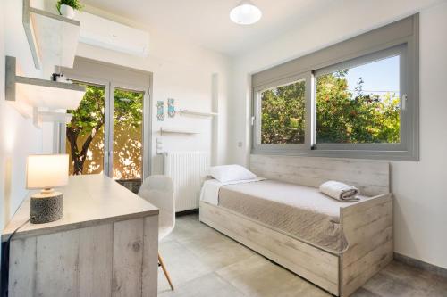 a bedroom with a bed and two windows at Peaceful house in Goúrnes