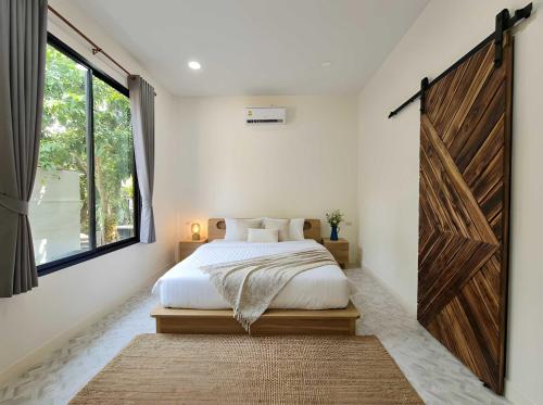 a bedroom with a bed and a large wooden door at Villa Vista in Wok Tum