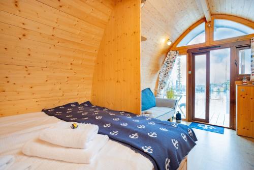 a bedroom with a bed in a wooden house at Hausboot Captain Hook in Stralsund