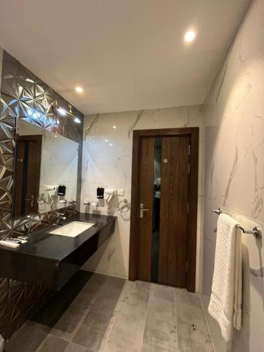 a bathroom with a sink and a large mirror at Brick House Hotel Lahore in Lahore