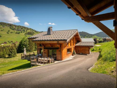 a log cabin in the mountains with a table and chairs at Chalet 1786 - OVO Network in Notre-Dame-de-Bellecombe