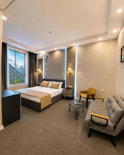 a hotel room with a bed and a couch and a chair at Mountain-city in Zaqatala
