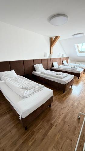 a row of beds in a room with wooden floors at Rynek 30 in Leżajsk