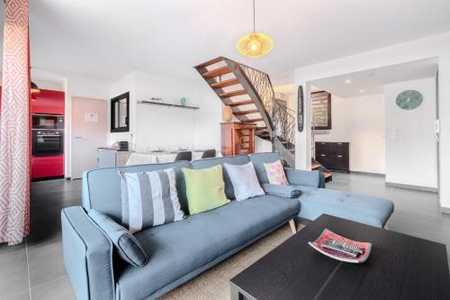 a living room with a blue couch and a table at Modern townhouse with parking in Toulouse