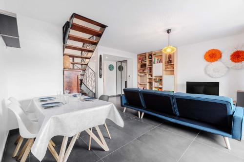 a living room with a blue couch and a table at Modern townhouse with parking in Toulouse