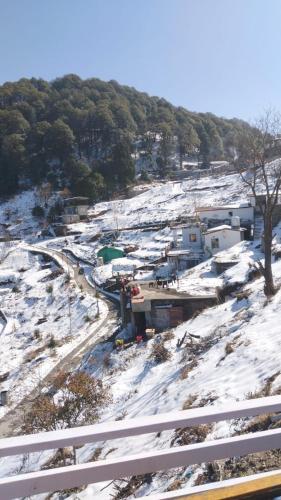 an aerial view of a snow covered field with buildings at Celestia peaks in Bhowāli