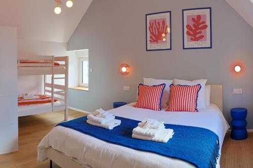 a bedroom with a bed with towels on it at Maison VENELL Concarneau - Spa, Balnéo, Sauna & Jardin - Calme en Centre-ville in Concarneau