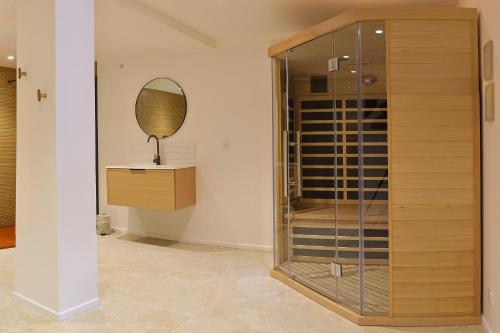 a glass closet with a mirror and a dresser at Maison VENELL Concarneau - Spa, Balnéo, Sauna & Jardin - Calme en Centre-ville in Concarneau