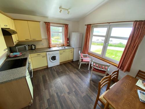 a kitchen with yellow cabinets and a table and chairs at The Kennels Ellary in Lochgilphead