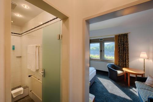 a hotel room with a bathroom and a bedroom at Hotel & Restaurant Walfisch in Würzburg