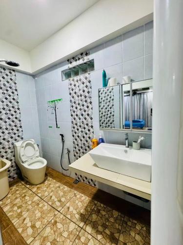 a bathroom with a white sink and a toilet at Best Day Homestay ! in Kangar