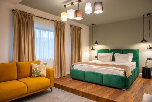 a bedroom with a green bed and a yellow couch at RUELLE Chateau Boutique- adults only in Sinaia