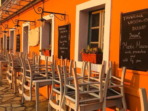 a row of tables and chairs outside of a restaurant at Loggos Harbour Suites in Longós