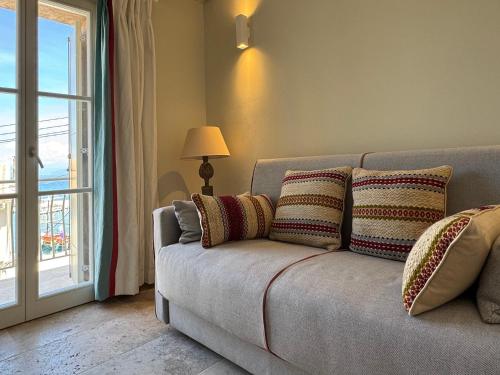 a couch with pillows in a living room with a window at Loggos Harbour Suites in Longós