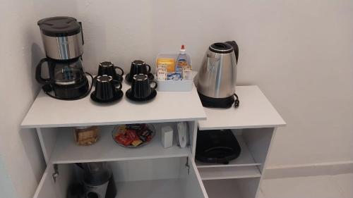a coffee maker and a coffeemaker on a shelf in a kitchen at Cantinho da Alzira - Sobrado in Iguaba Grande