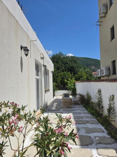 a stone walkway between two white buildings at Villa Iper Krystallos in Budva