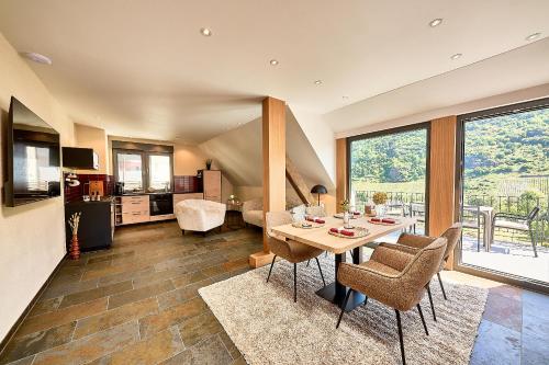 a kitchen and living room with a table and chairs at Wohnen am Weingut - Auf dem Ausguck in Briedel