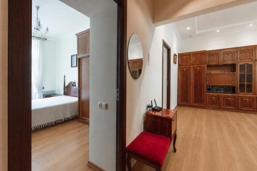 a room with a red chair and a bedroom at Large apartment by the Opera- luxury living room, 2 bedrooms, equipped kitchen and balcony in Yerevan