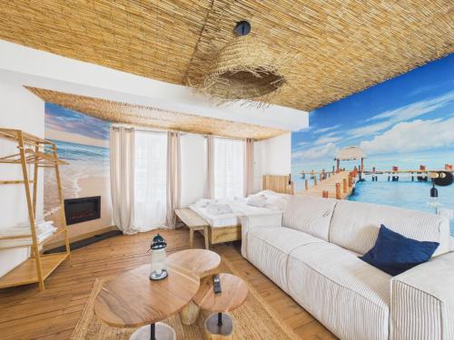 a living room with a couch and a view of the ocean at Arden Suites Hébergements à thème in Charleville-Mézières