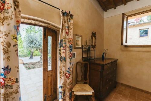 a room with a door and a dresser and a window at La Pimpinella di Semifonte in San Donnino