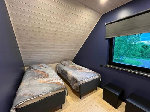 two beds in a room with a window at Mihkliranna Puhkemaja in Marksa