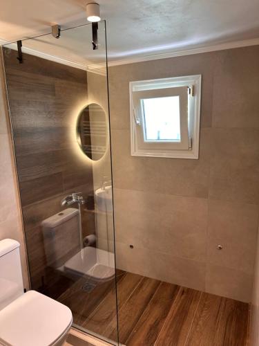 a bathroom with a shower and a toilet and a window at Gabriel's House Angonas in Angón