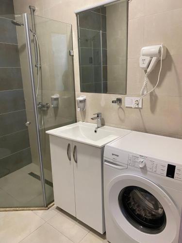 a bathroom with a washing machine and a sink at Coastal Breeze Apartment in Batumi