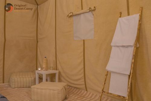 a tent with a chair and towels in it at Original Desert Camp in Merzouga