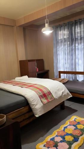 a bedroom with two beds and a rug at Ang Ds Homestay in Sonāda