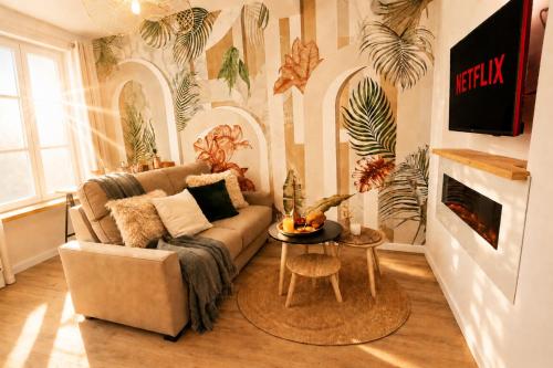 a living room with a couch and a table at MRODBNB - Appart Neuf - Aperçu Mer - 25m Plage & Resto - Ciné - cheminée - Popcorn in Cancale