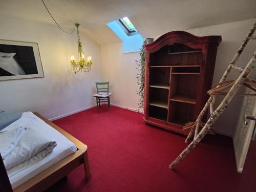 a bedroom with a bed and a chair and a shelf at Abendsonne in Saulgrub