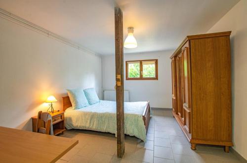 a bedroom with a bed and a table and a window at Le gite de la cea in Saint-Mards-en-Othe