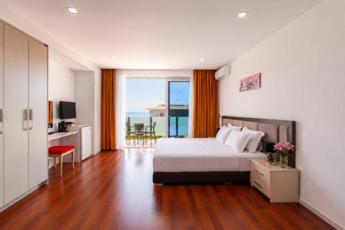 a hotel room with a bed and a balcony at 3B Suites Boutique Hotel in Sarandë