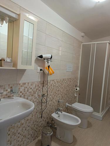 ein Badezimmer mit Waschbecken, Toilette und Dusche in der Unterkunft Da Rita in Gerace