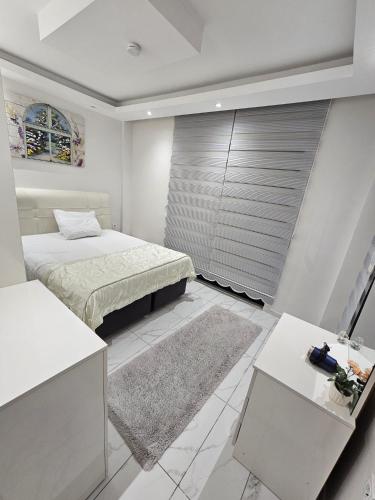 a white bedroom with a bed and a table at Paradise Garden sitesi 3 oda havuzlu eşyalı daire kişi fiyatı değil oda fiyatı in Side